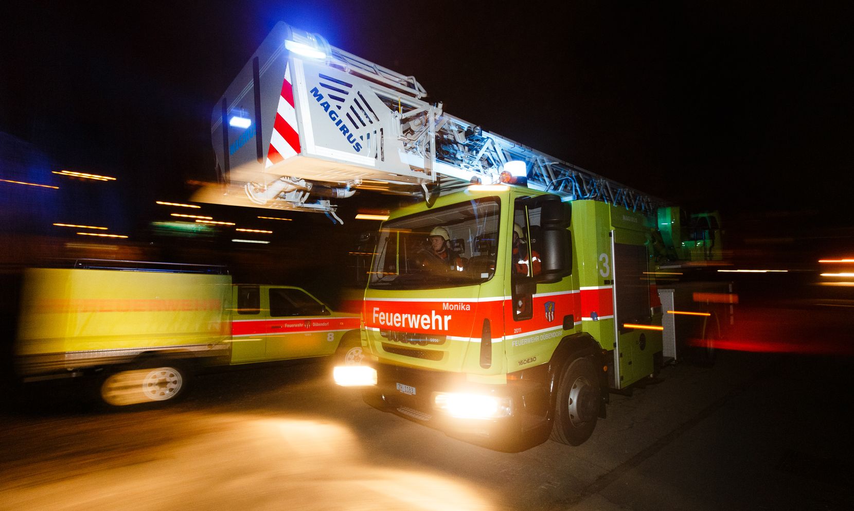 Man sieht ein Feuerwehrauto in der Nacht