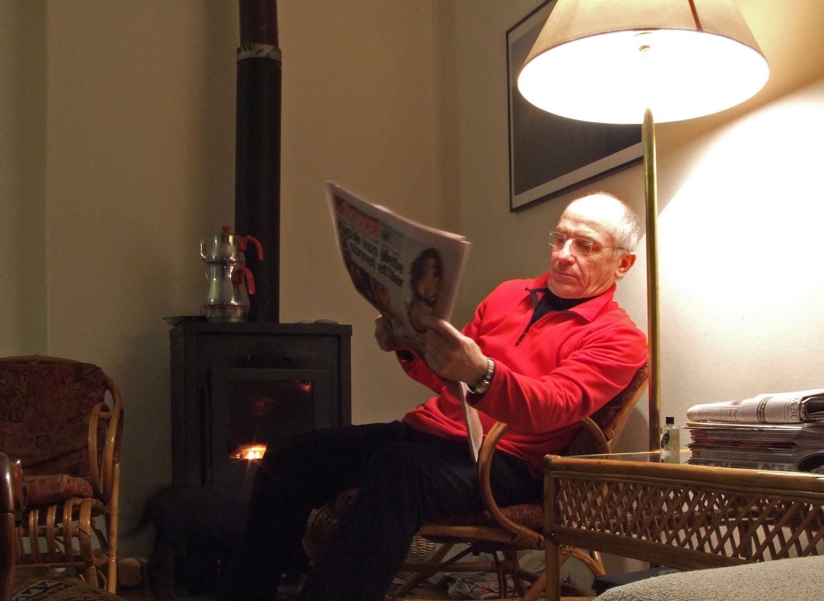 Rentner liest in einer Wohnung eine Zeitung. 