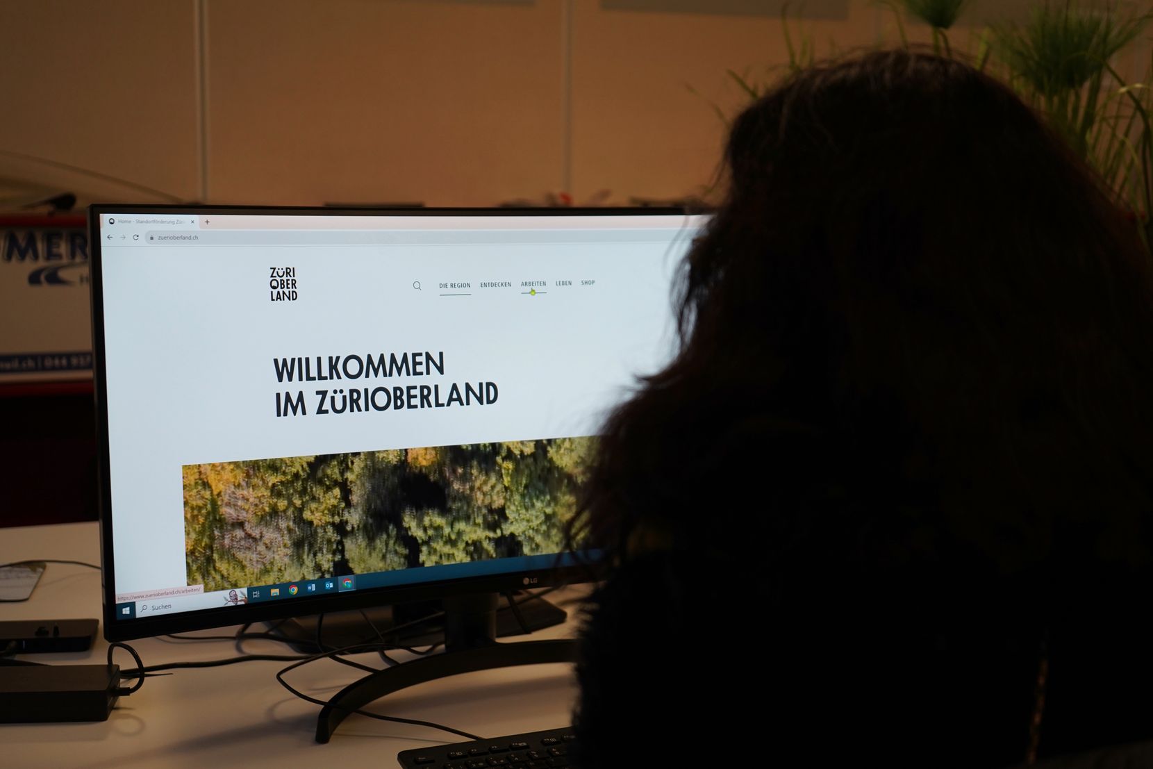 Auf dem Bild ist eine junge Frau zu sehen, die sich die neue Website der Standortförderung Zürioberland anschaut.