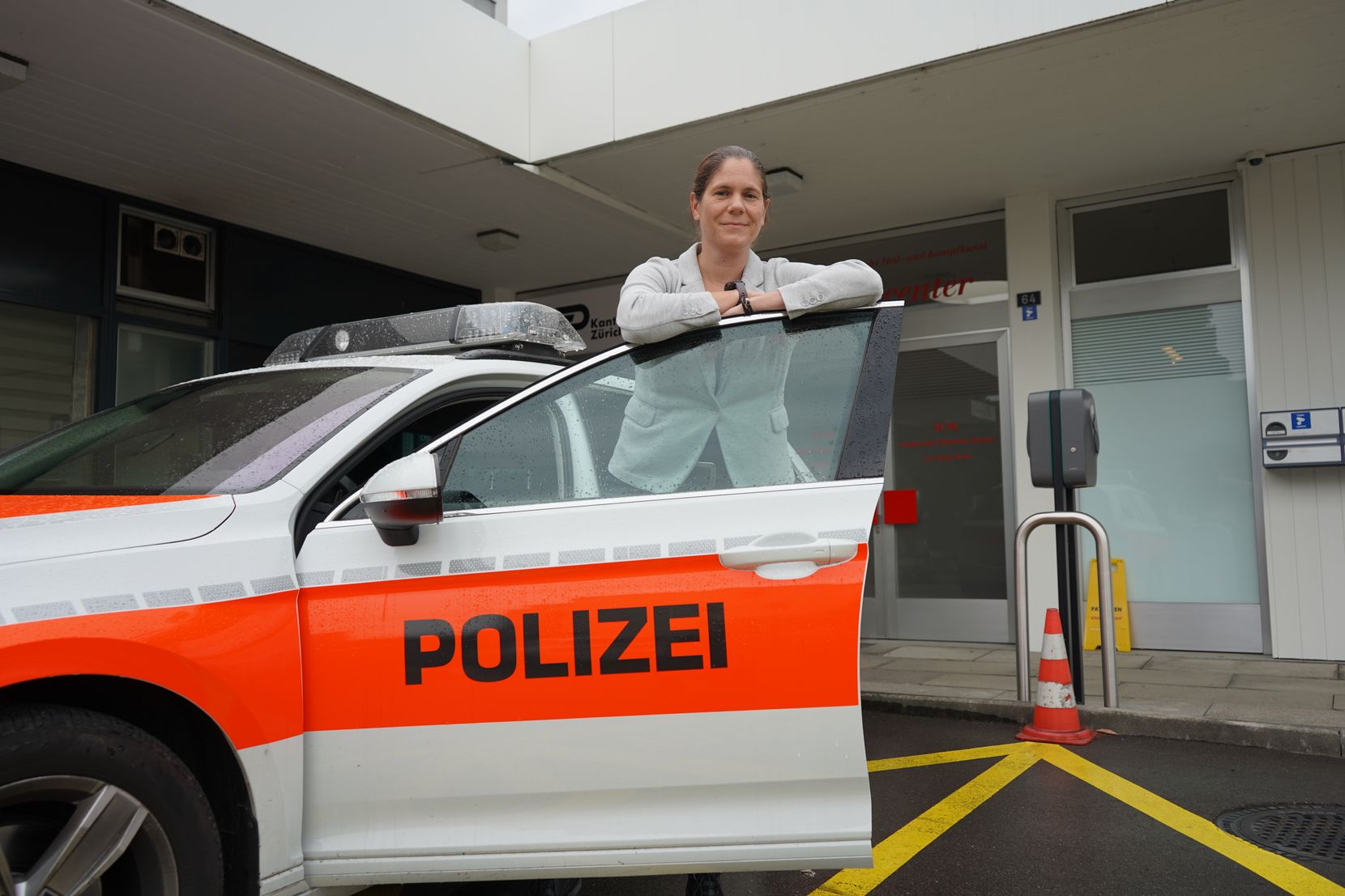 Eine Frau vor einem Polizeiauto.