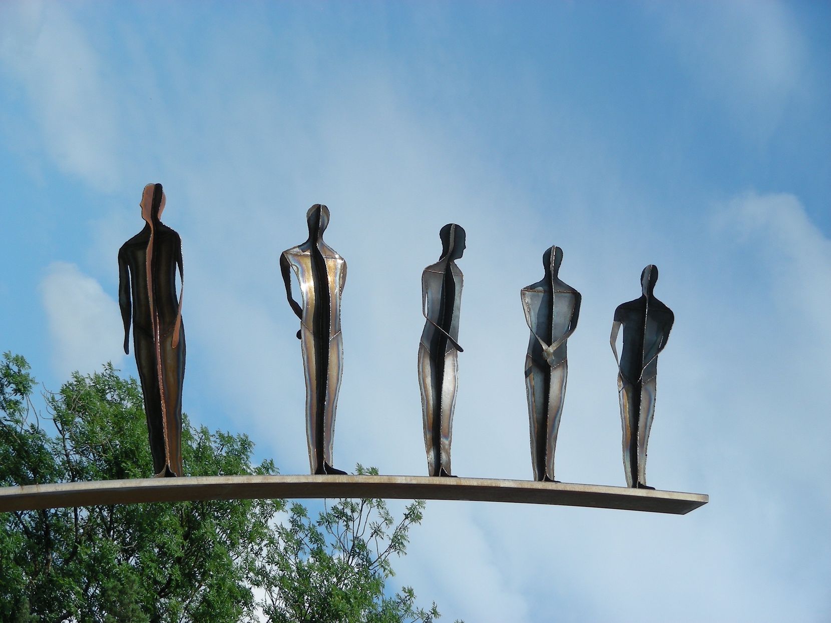 Eine Skulptur mit fünf silbernen Männern.