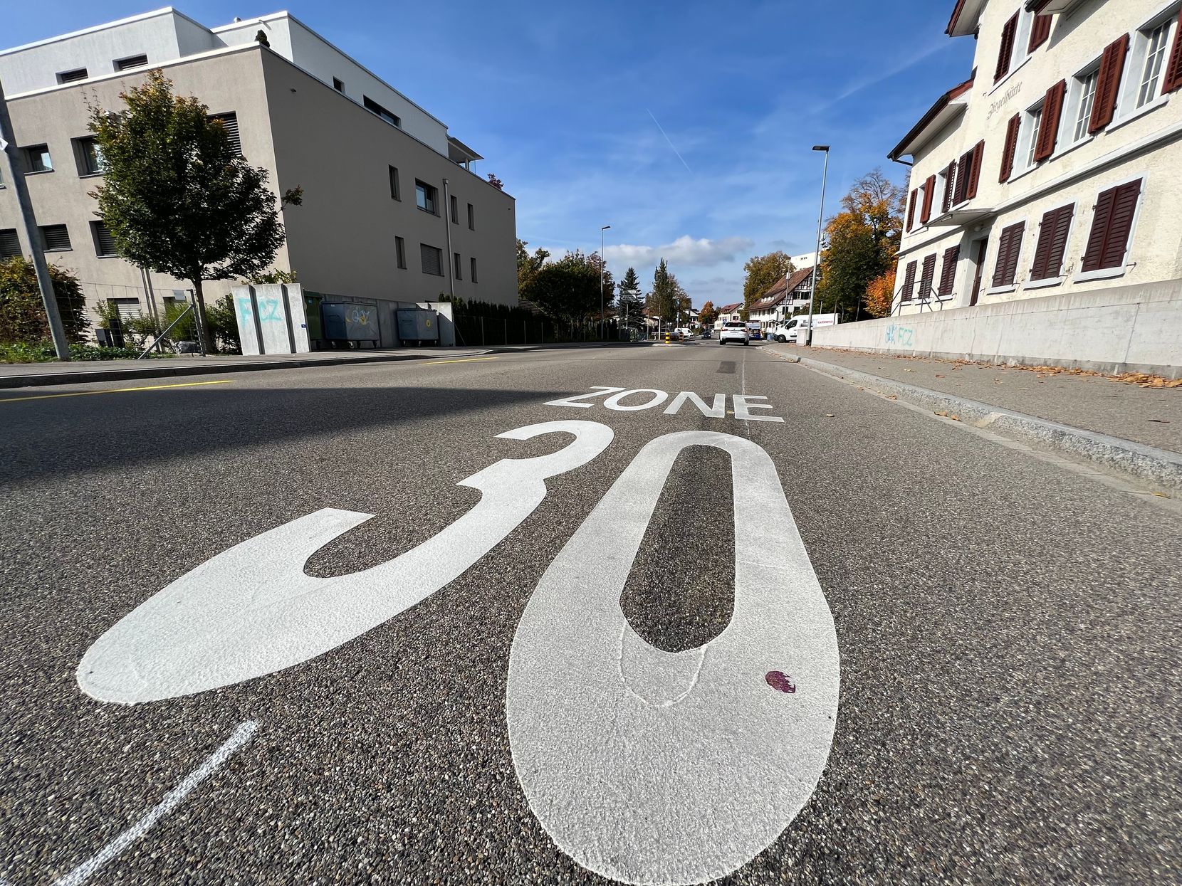 Auf dem Foto sieht man eine grosse Zahl 30 auf der Strasse, die die Tempo-30-Zone signalisiert.