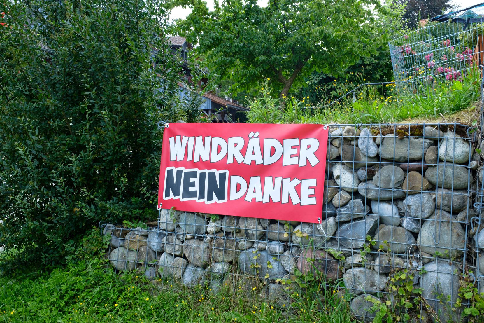 Ein rotes Transparent mit der Aufschrift «Windkraft Nein Danke» hängt an einer Strasse in Hermatswil.