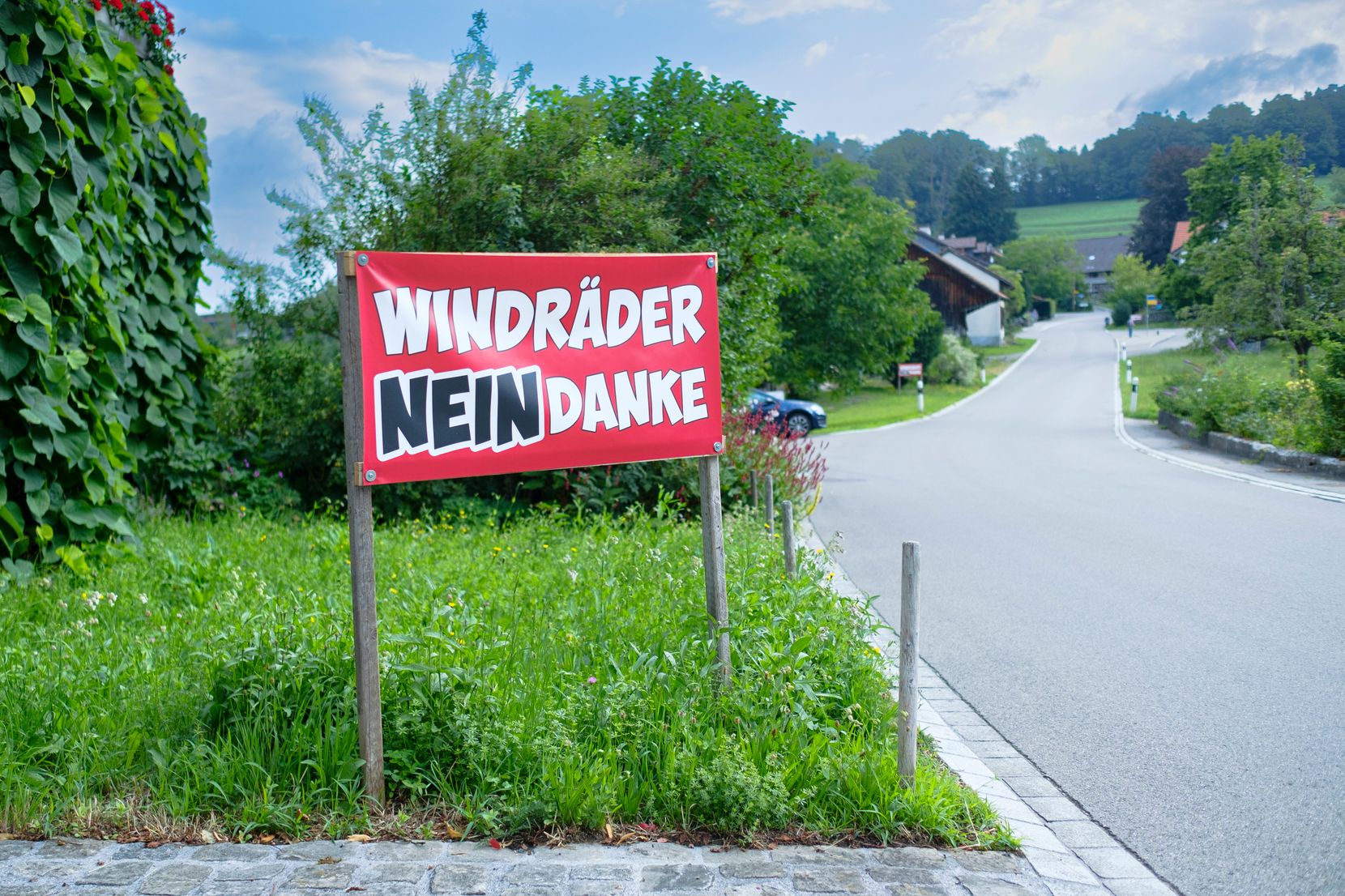 in rotes Transparent mit der Aufschrift «Windkraft Nein Danke» steht an einer Strasse in Hermatswil.