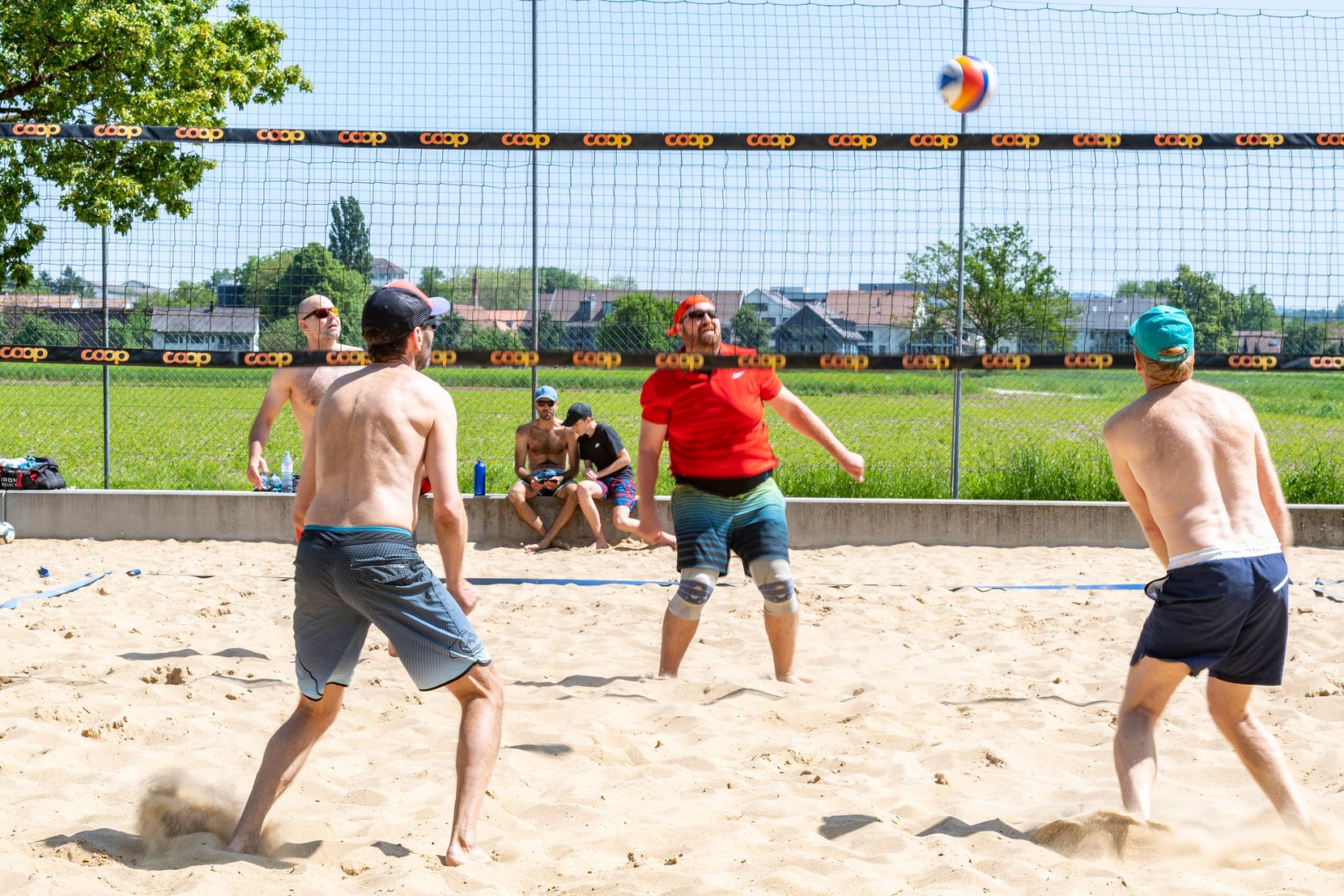 Männer spielen in der Hitze auf dem Sand.