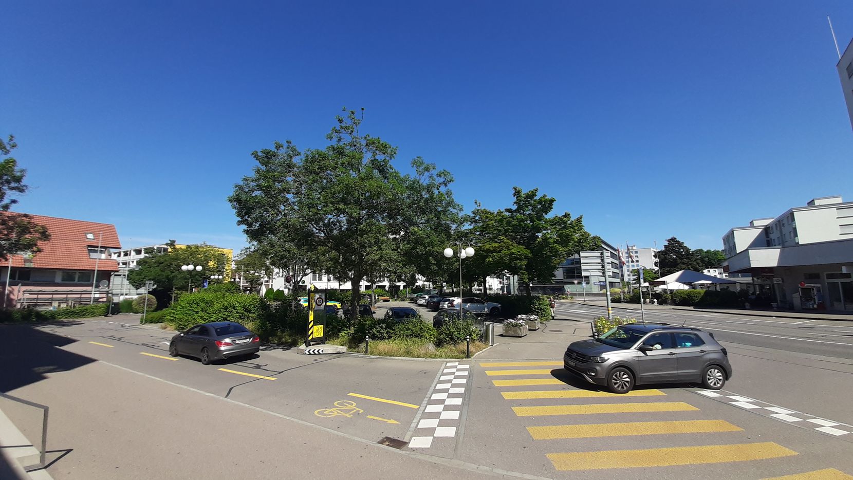 Ein Parkplatz mit Autos und Bäumen im Zentrum einer Agglomerationsstadt.