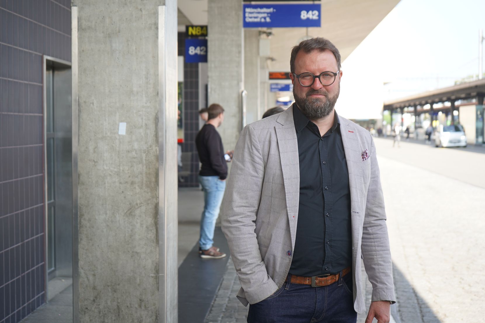 Patrick Neuhaus steht am Busbahnhof in Uster und lächelt in die Kamera.