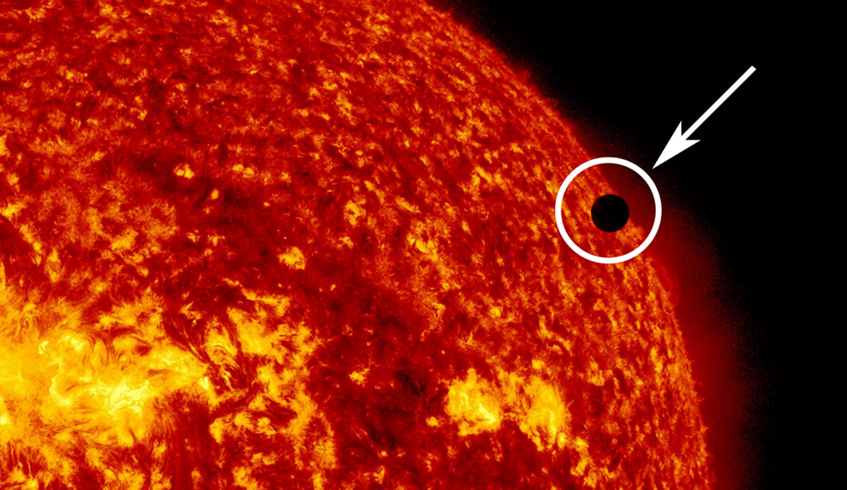 Ein Bild der Sonne mit einem kleinen schwarzen Fleck, der die Venus darstellt.