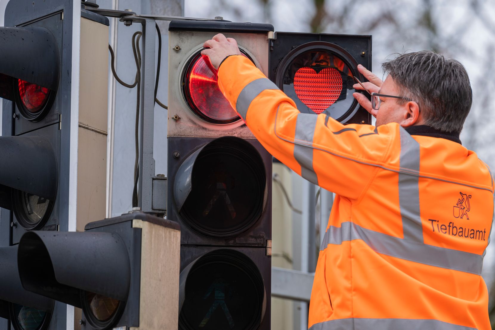 Foto von Herzli-Ampel mit Raymond König, Erfinder der Aktion und Leiter Tiefbauamt.