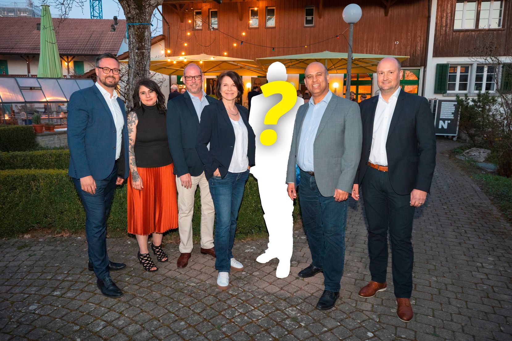 Der Gemeinderat (von links) Michael De Vita-Läubli l (GLP), Ioana Mattle (GLP), Marcel Egloff (FDP), Karin Ayar (FDP), ?, Jean-Philippe Pinto (Die Mitte) und Thomas Brauch (SVP). Die dritte Person von rechts ist nur eine weisse Silhouette mit einem gelben Fragezeichen.