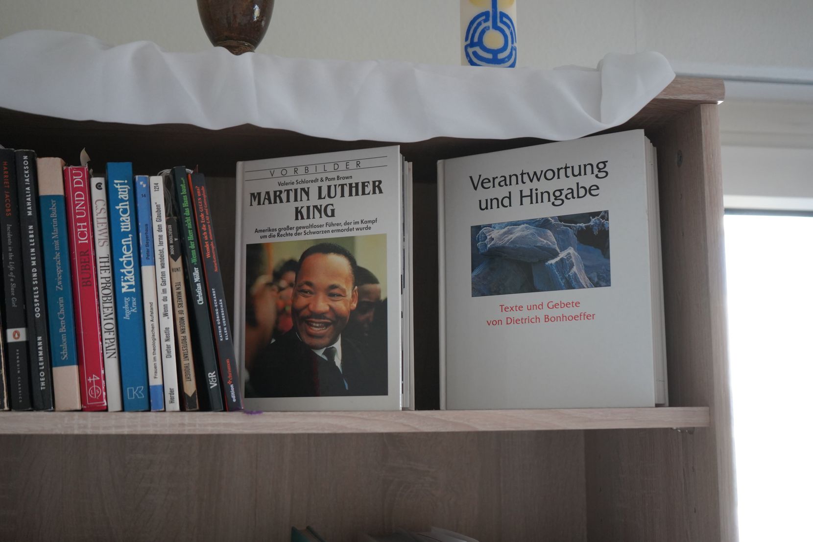 Zwei Bücher über Martin Luther King und Dietrich Bonhoeffer in einem Regal.