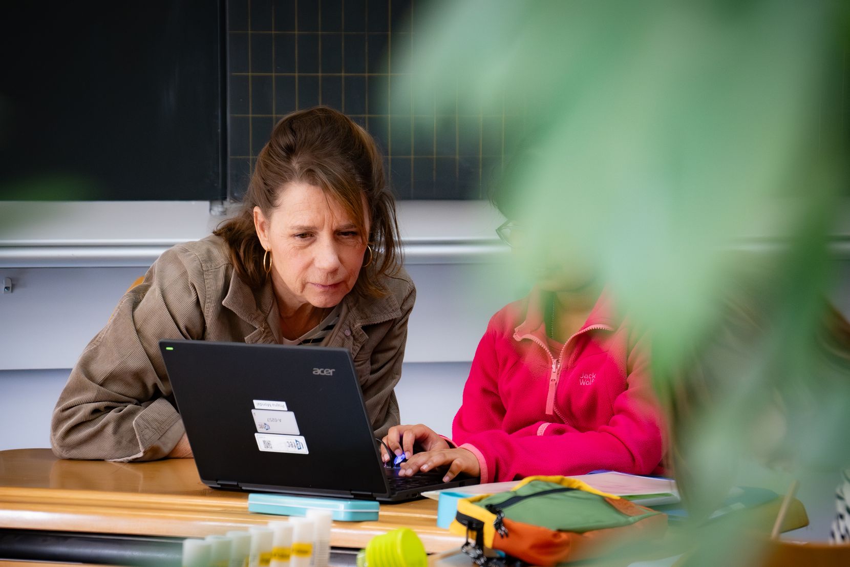 Eine Frau und ein Kind schauen auf einen Laptopbildschirm. 