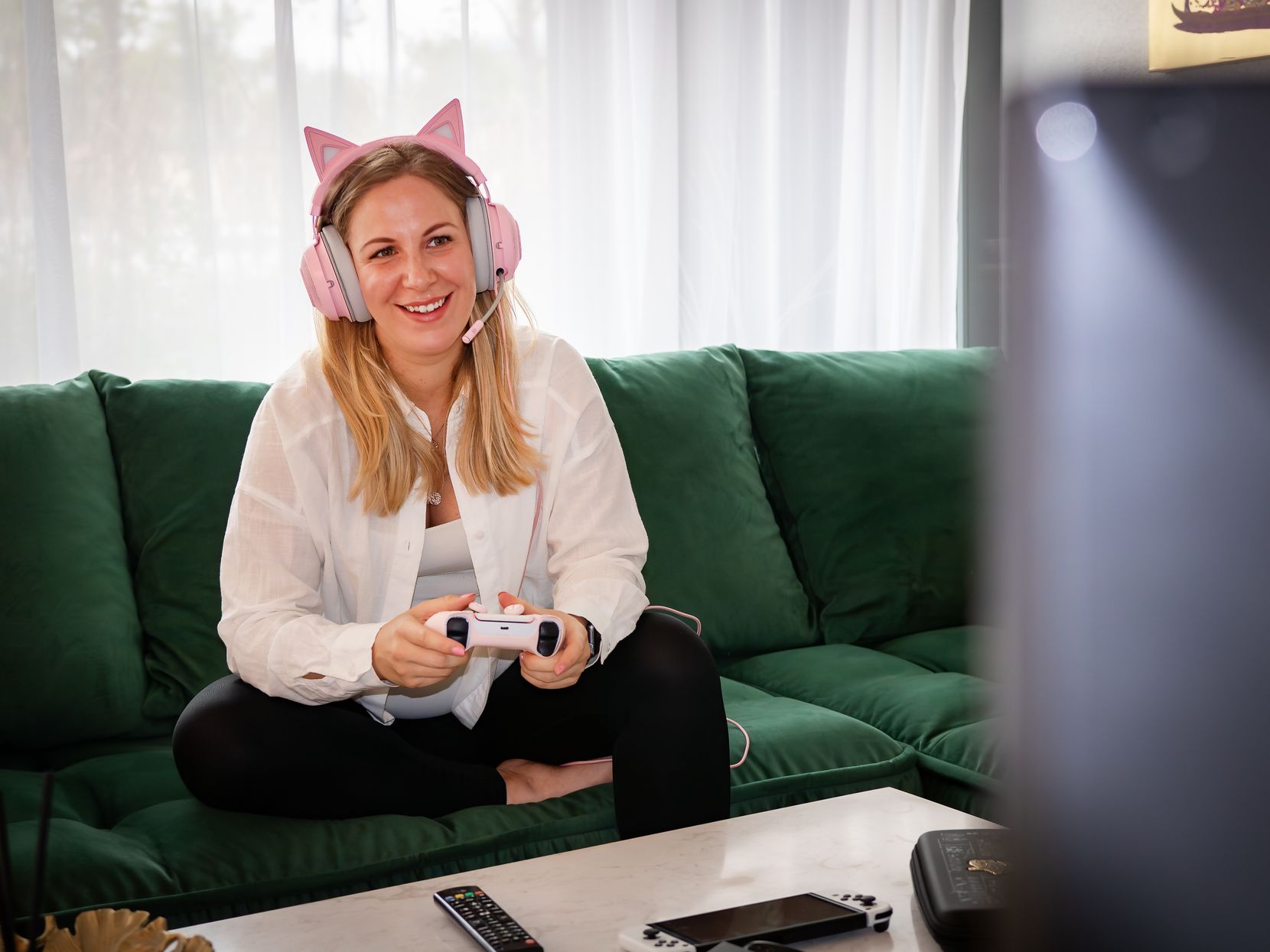 Frau mit Katzenohren-Headset spielt Videospiel. 