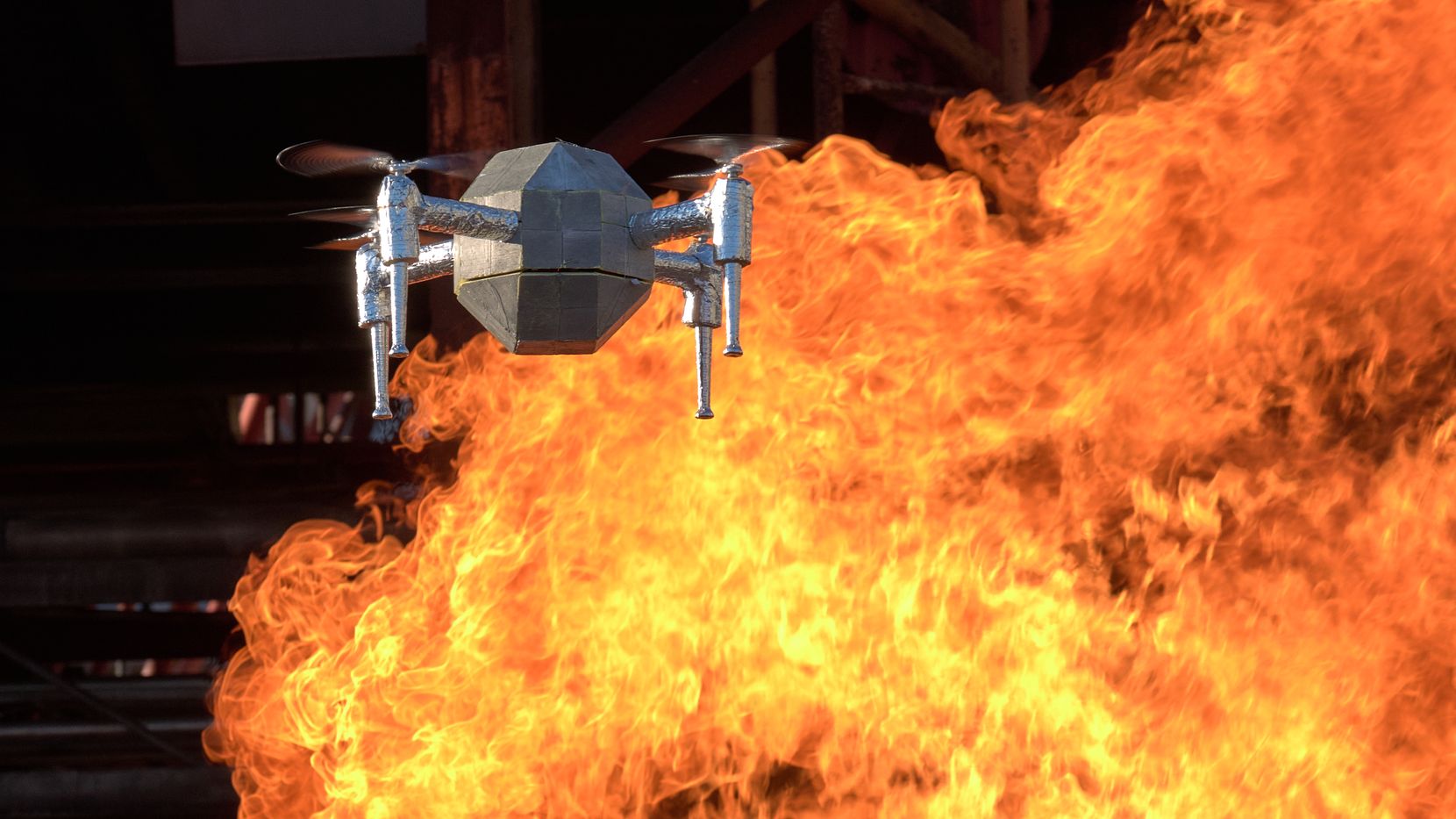 Eine Drohne vor einer Flammenwand.