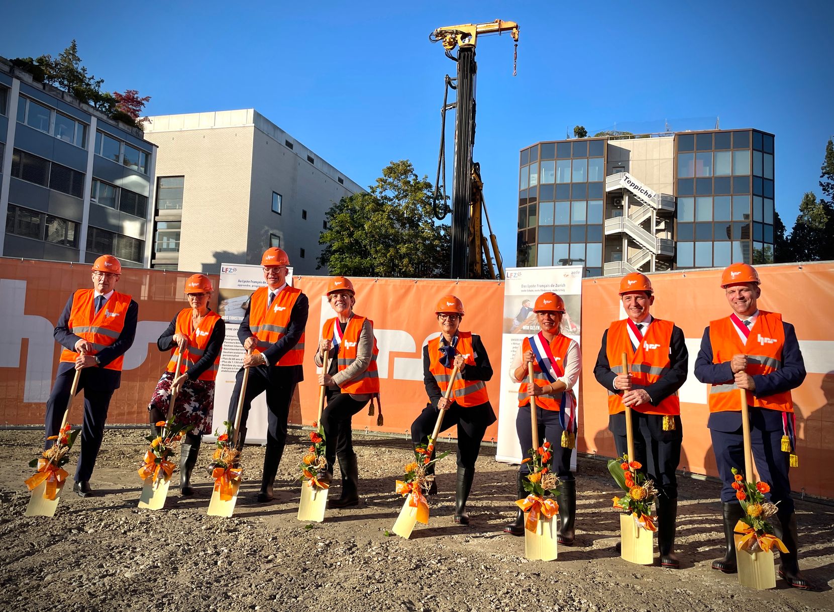 Mehrere Verantwortliche posieren mit einer Schaufel auf der Baustelle für das neue Gebäude des Lycée Français in Dübendorf.