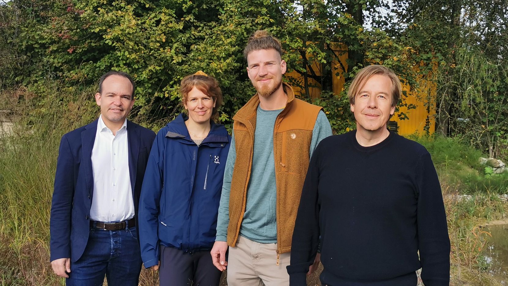 Vier Personen schauen in die Kamera.