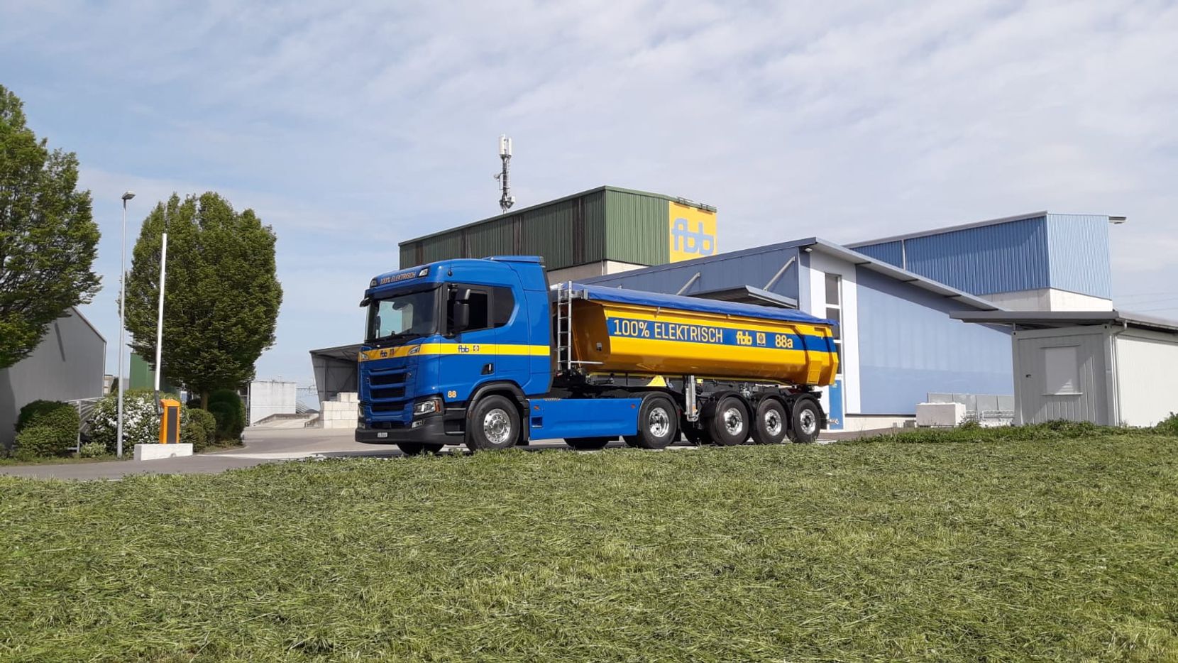 Ein in den Farben Blau und Gelb gehaltener Sattelschlepper der Firma FBB von Scania. Das Fahrzeug fährt batterieelektrisch.