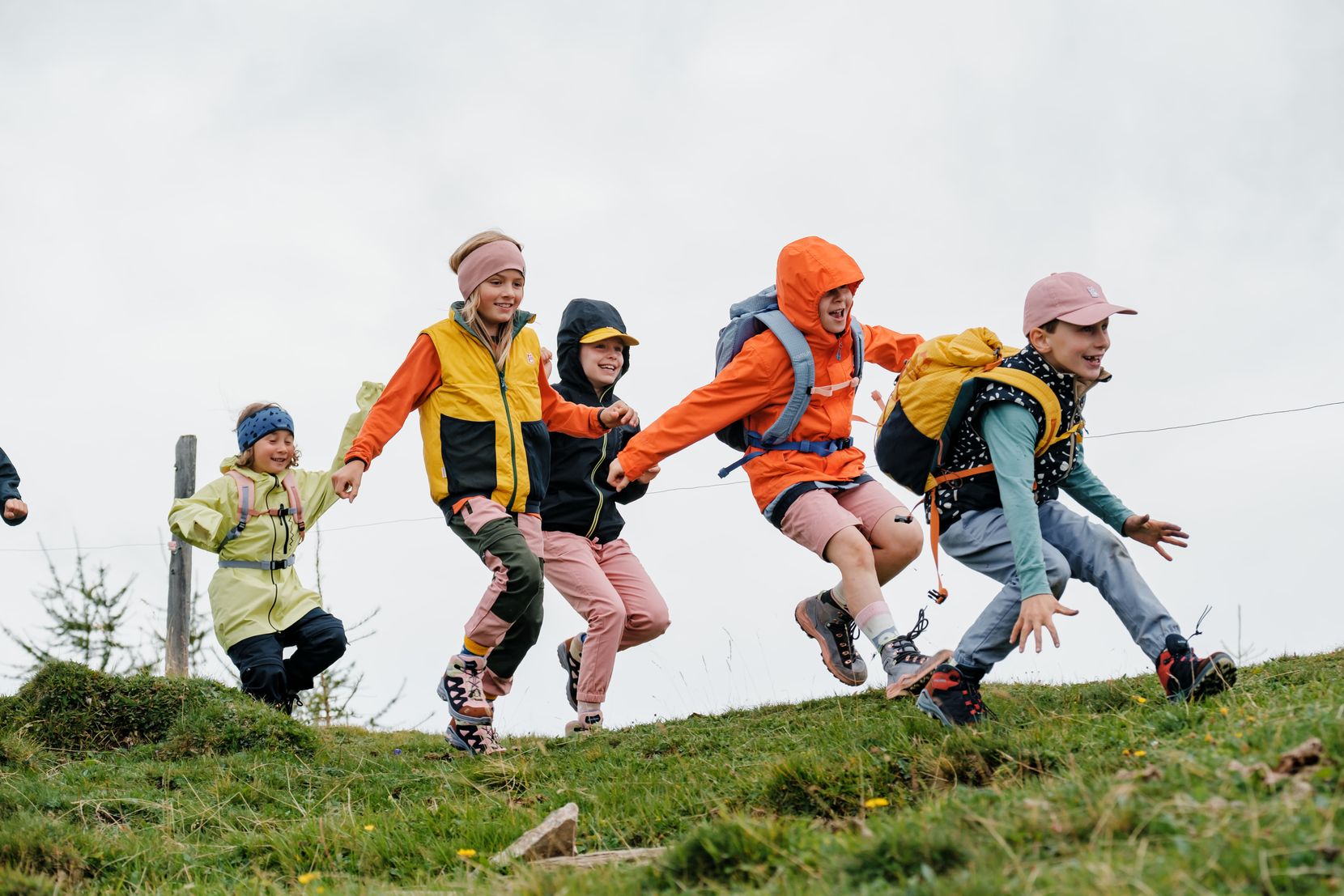 Eine Gruppe von Kindern rennt über eine Wiese.