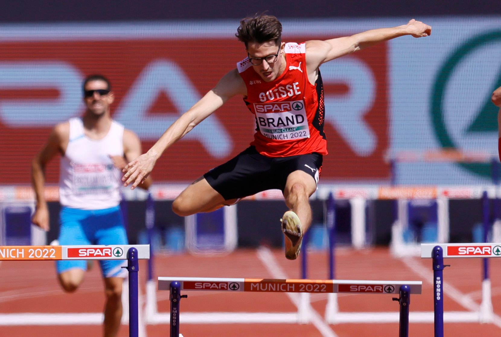 epa10125359 Dany Brand of Switzerland clears the hurdles of the mens 400m Hurdles during the Athletics events at the European Championships Munich 2022, Munich, Germany, 17 August 2022.  EPA/RONALD WITTEK