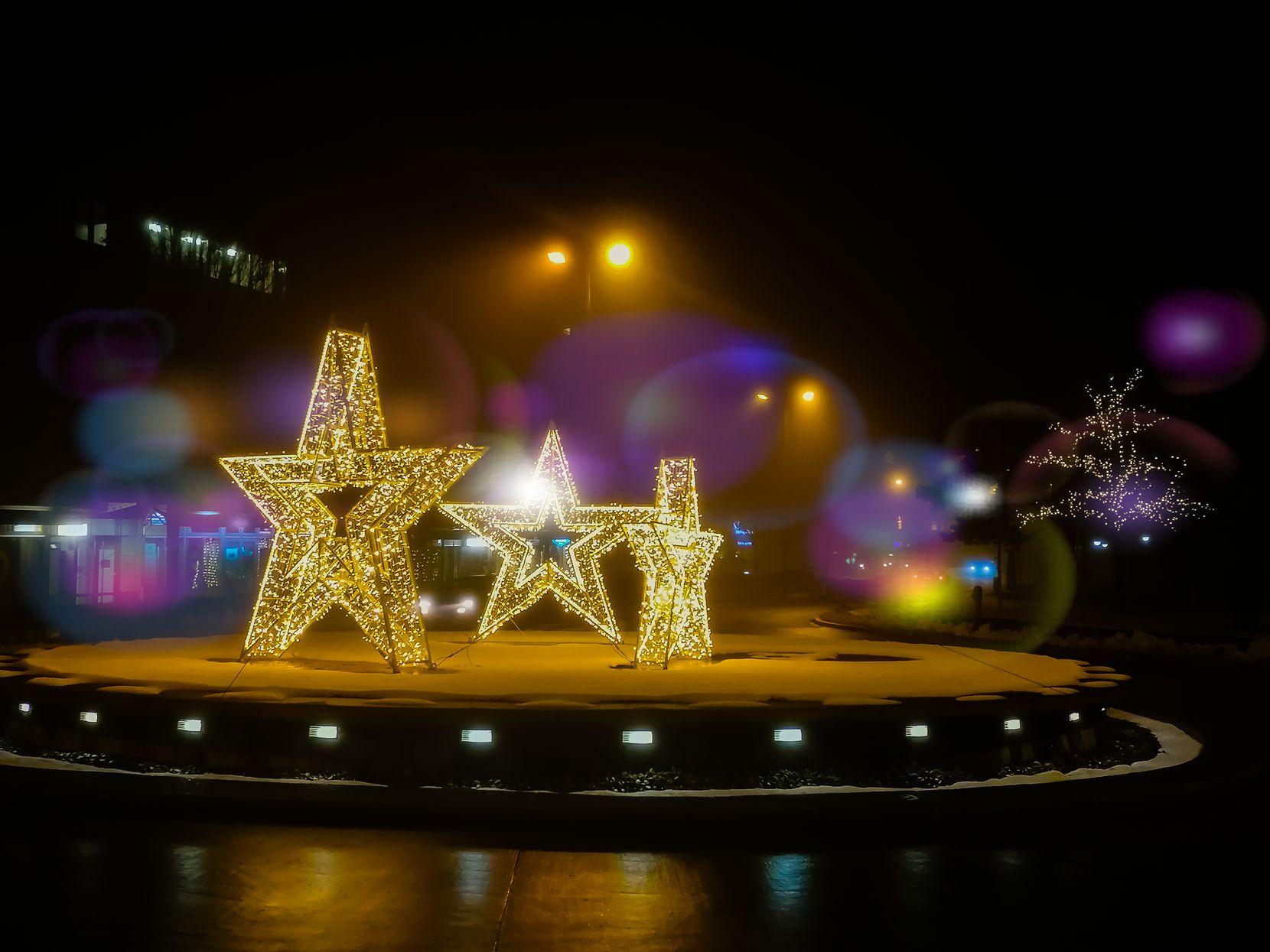 Drei grosse Sterne leuchten auf einem Verkehrsreisel.