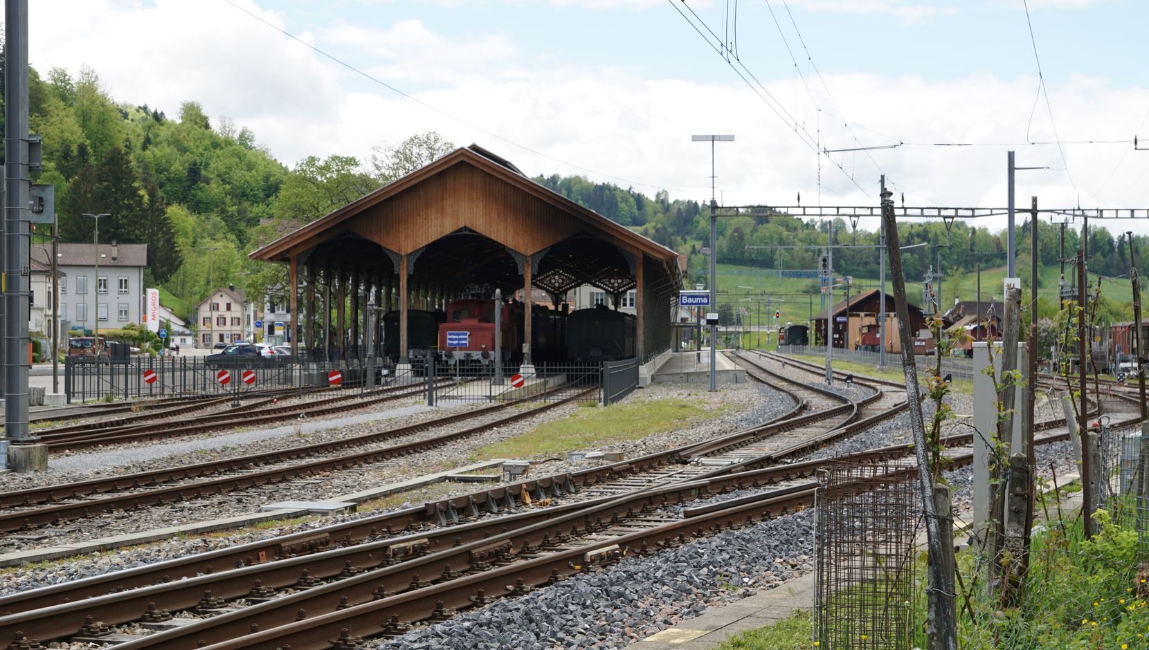 Ein altes Eisenbahnareal mit Gleisen und Halle.