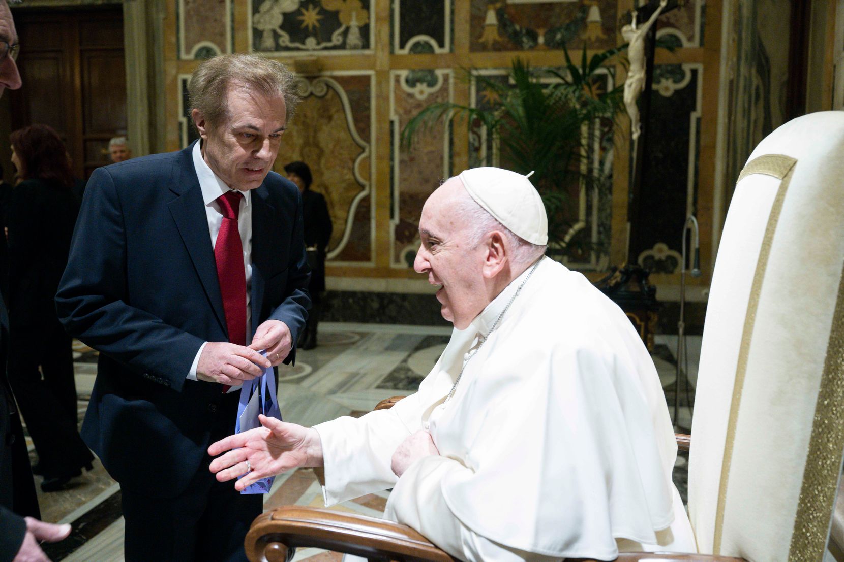 Man sieht einen Mann im Anzug und Papst Franziskus.
