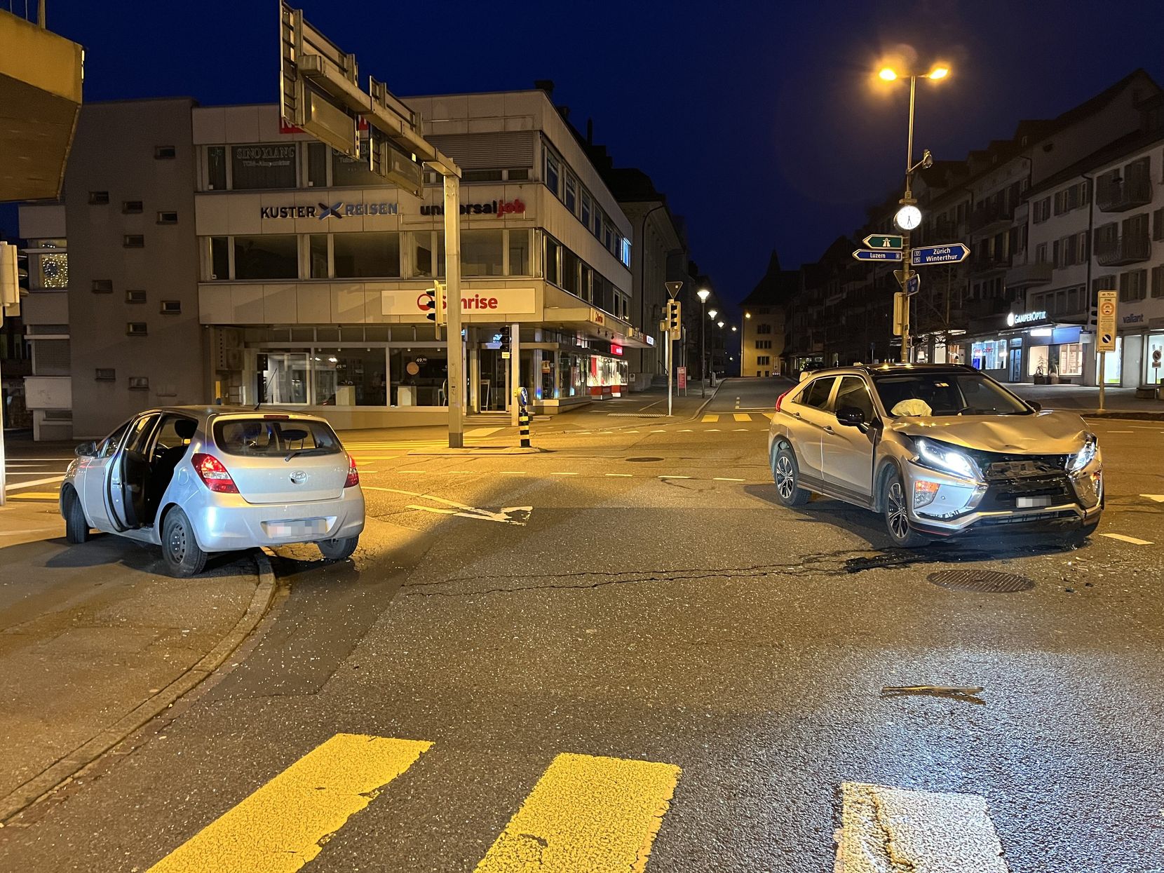 Zwei beschädigte Autos stehen auf einer Kreuzung mitten in Rapperswil.