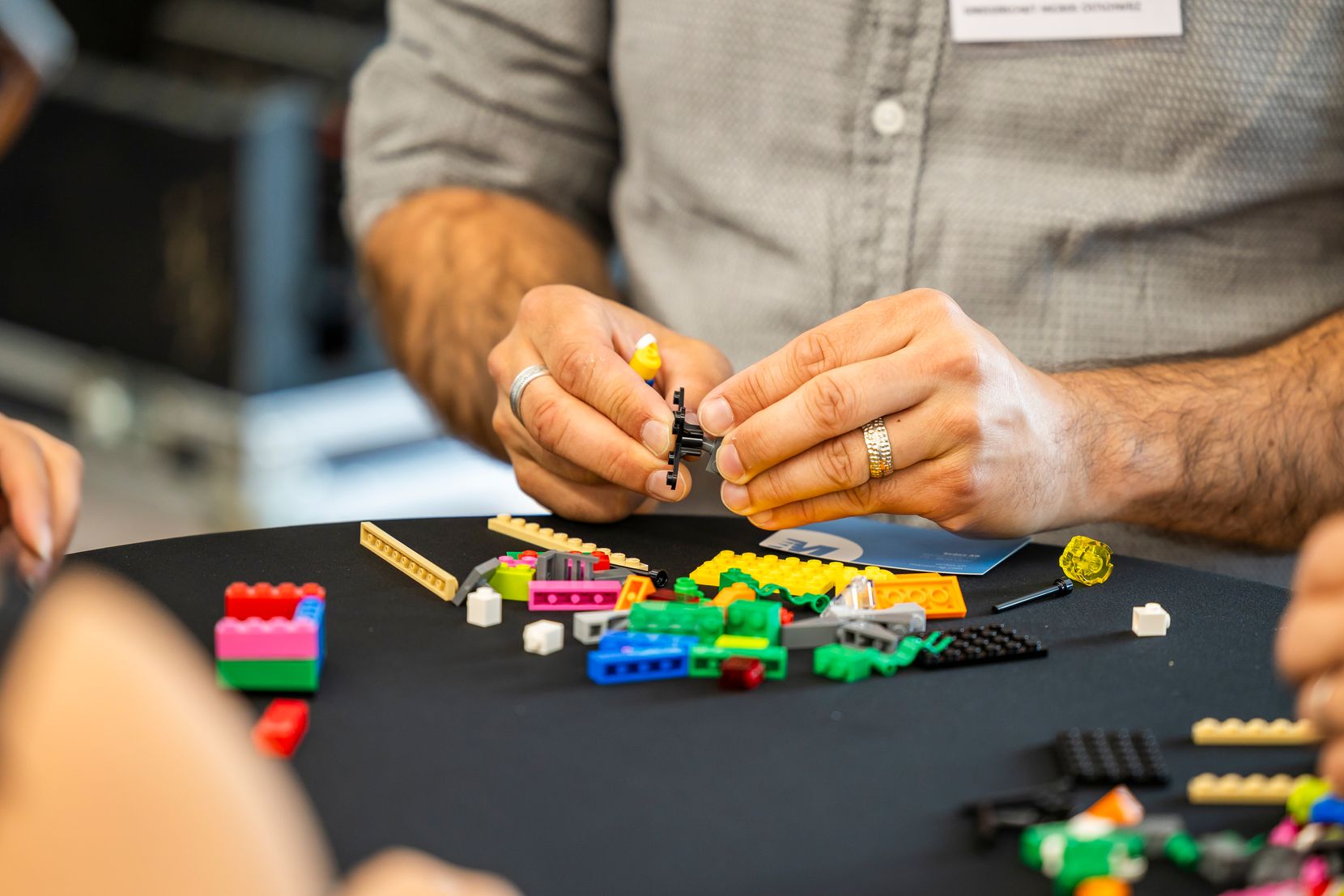 Close-up auf zwei männliche Hände, die Lego in den Händen hält und etwas baut.