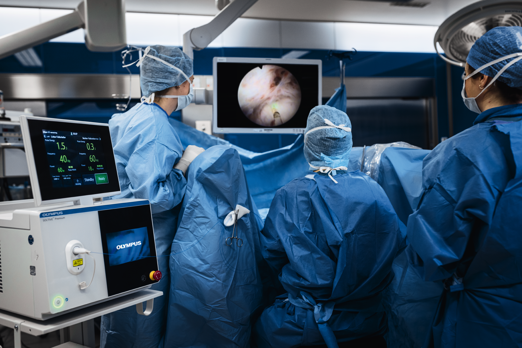 In einem Operationssaal stehen drei Chirurginnen und führen einen Eingriff  durch.