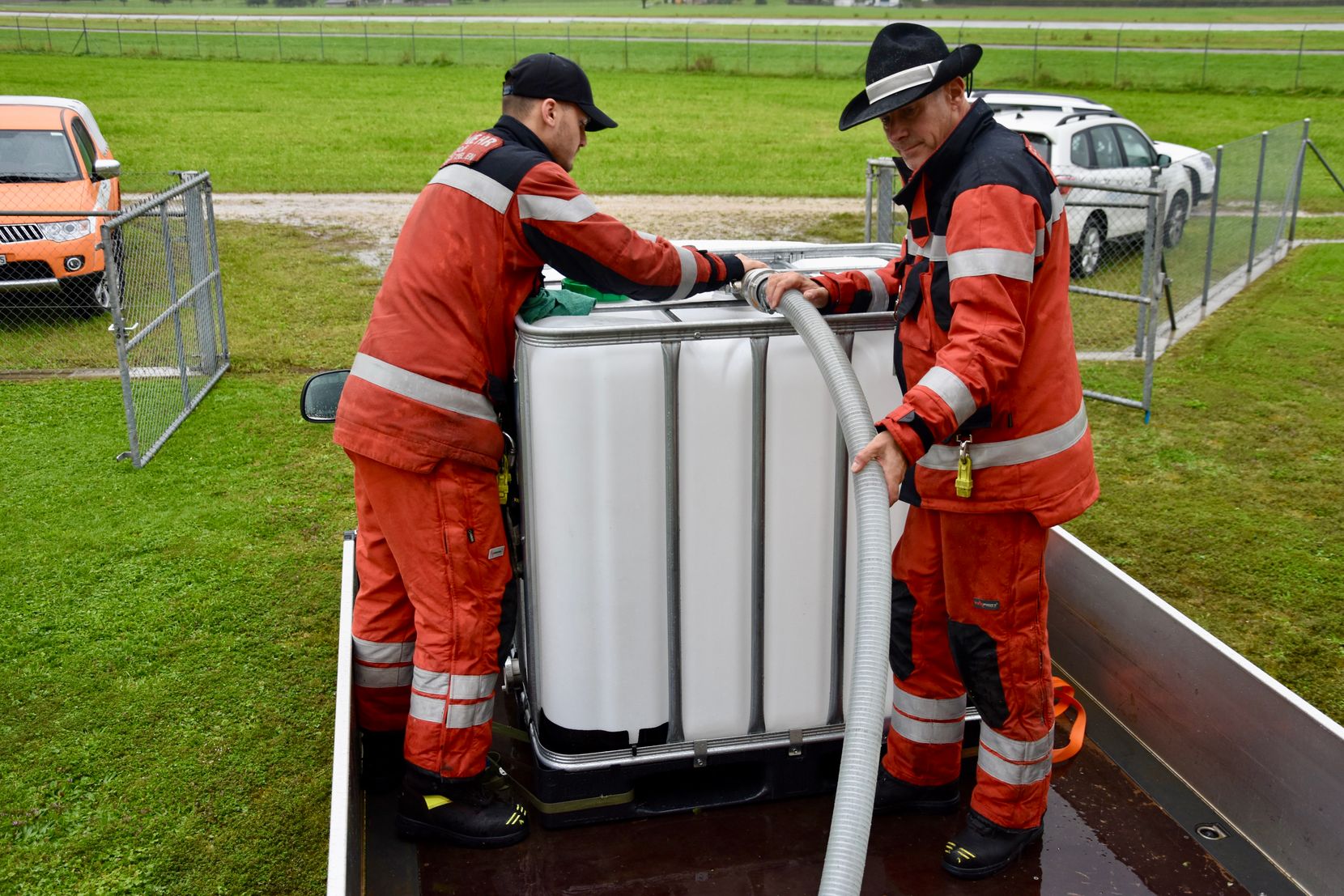 Zwei Feuerwehrmänner füllen einen Tank.