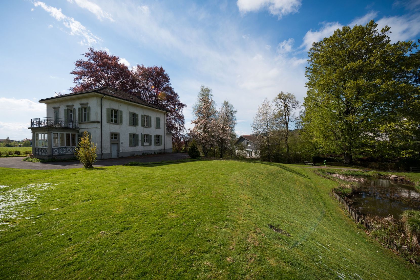 Die Villa in Weiss auf einer Wiese im Luppmenpark