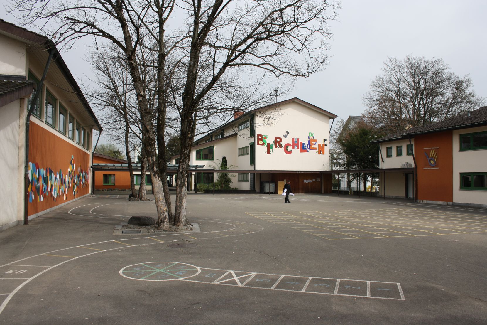 Ein Schulhaus aus den 1960er Jahren mit Pausenplatz.