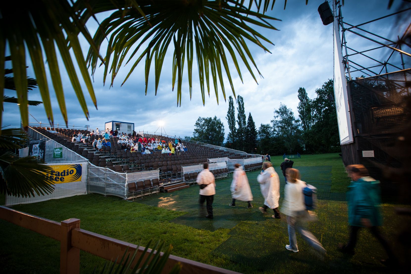 Besucher nehmen mit Regenpelerinen ihre Plätze beim Open-Air-Kino in Uster ein. 