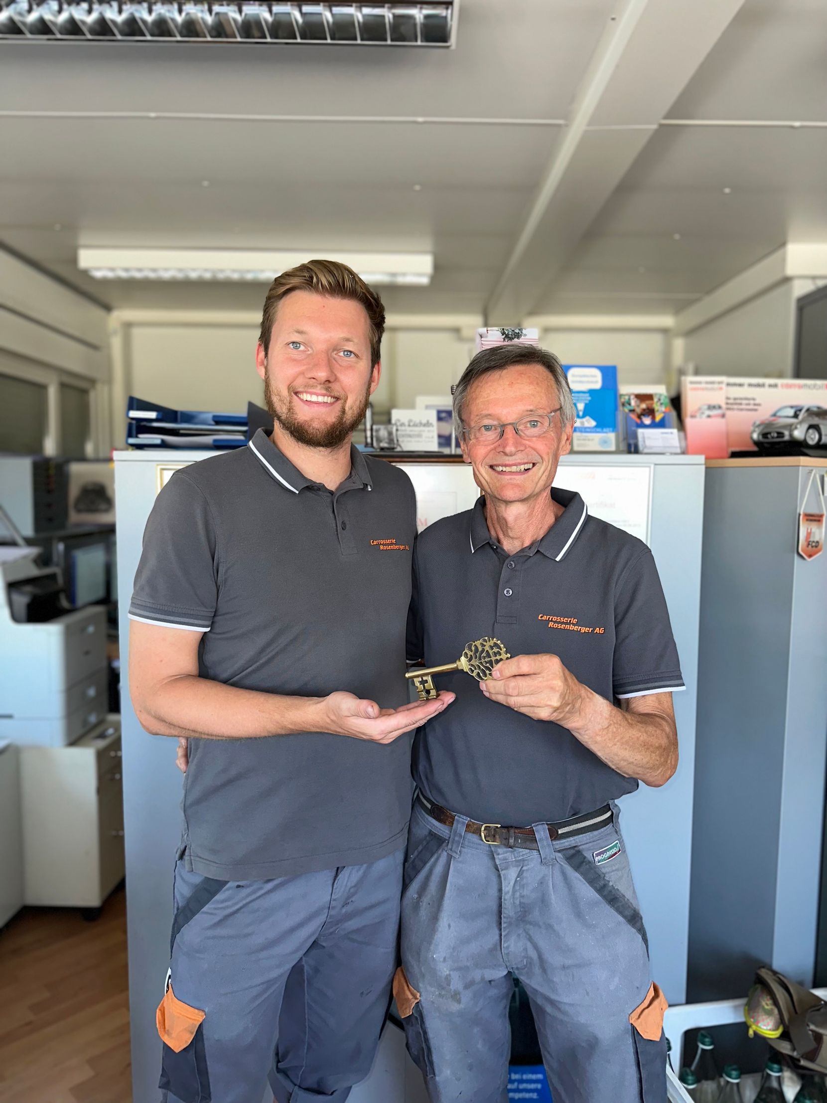 Das Foto zeigt Daniel Angliker, der neue Inhaber der Carrosserie Rosenberger AG (links), mit dem ehemaligen Inhaber Markus Angliker bei der Schlüsselübergabe.