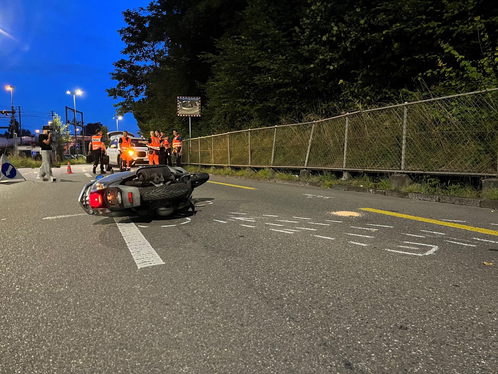 Ein Motorroller liegt nach einem Unfall auf einer Strasse.