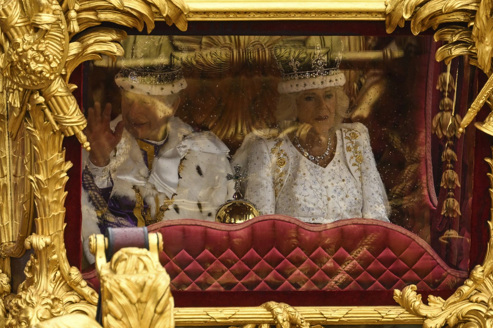 Ein Königspaar voll Prunk und Pracht in einer vergoldeten Kutsche.