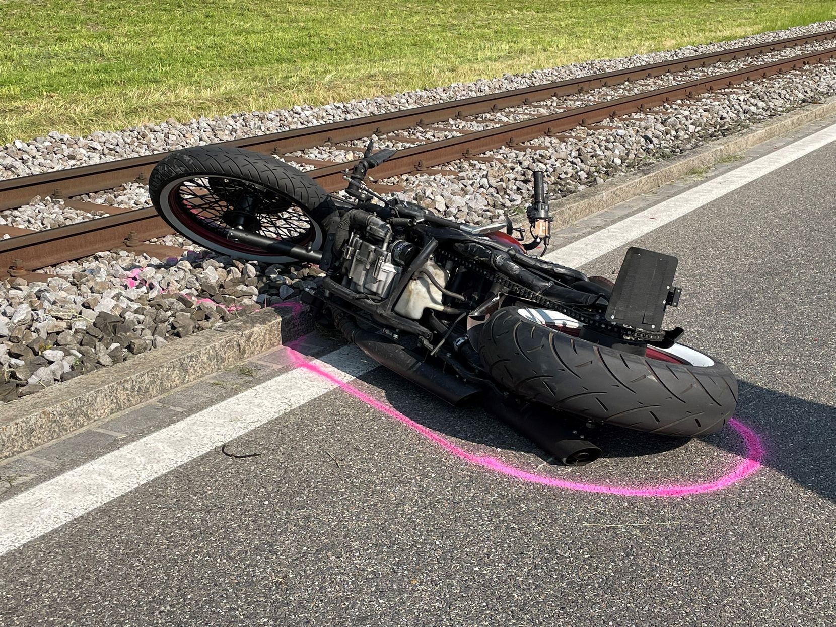 Ein verunfalltes Motorrad liegt auf der Strasse. Die Spurensicherung hat eine rosarote Linie um die Maschine gemalt.