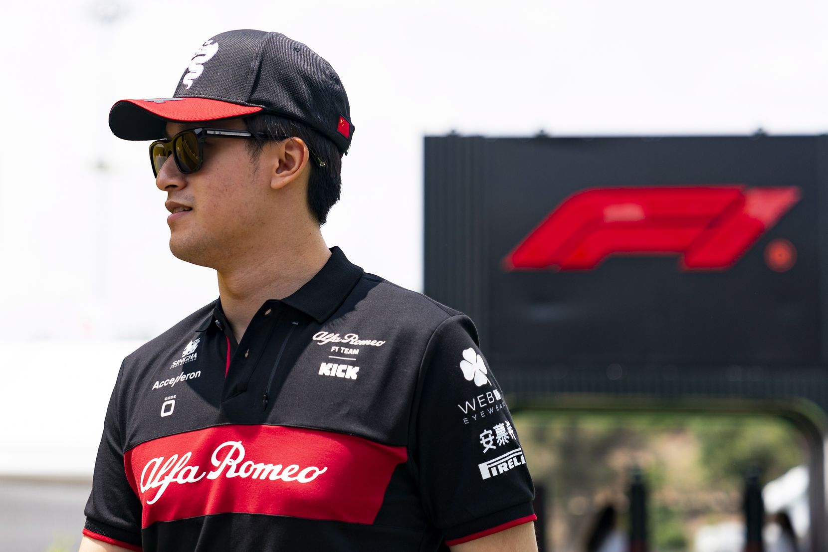 Ein junger Chinese in der Teambekleidung von Alfa Romeo-Sauber.