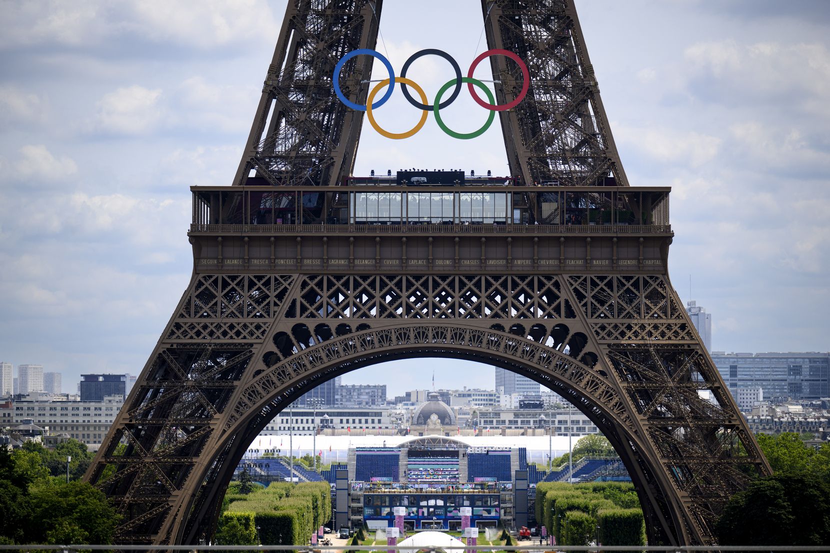 Man sieht den Eiffelturm in Paris. Die olympischen Ringe befinden sich vor diesem. 