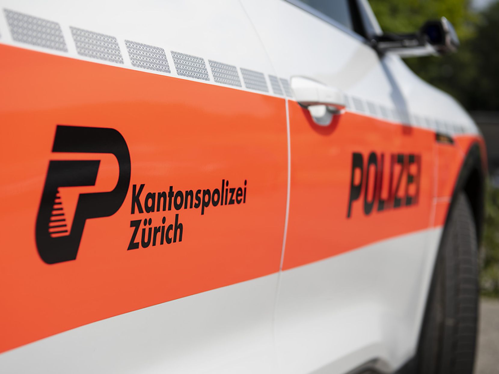 Orange-weißes Polizeifahrzeug.