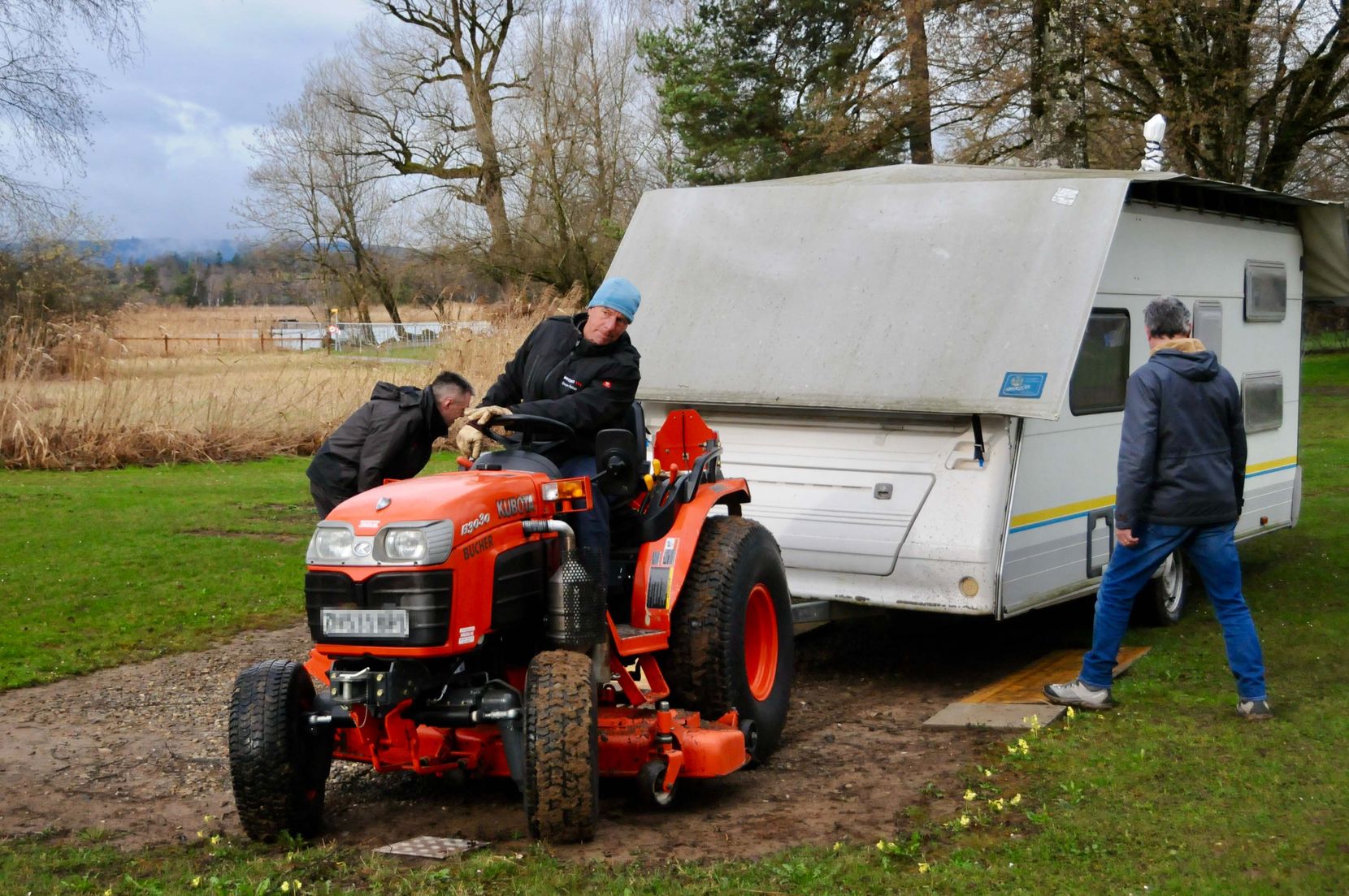 Ein Traktor und ein Wohnwagen auf dem Campingplatz Auslikon.