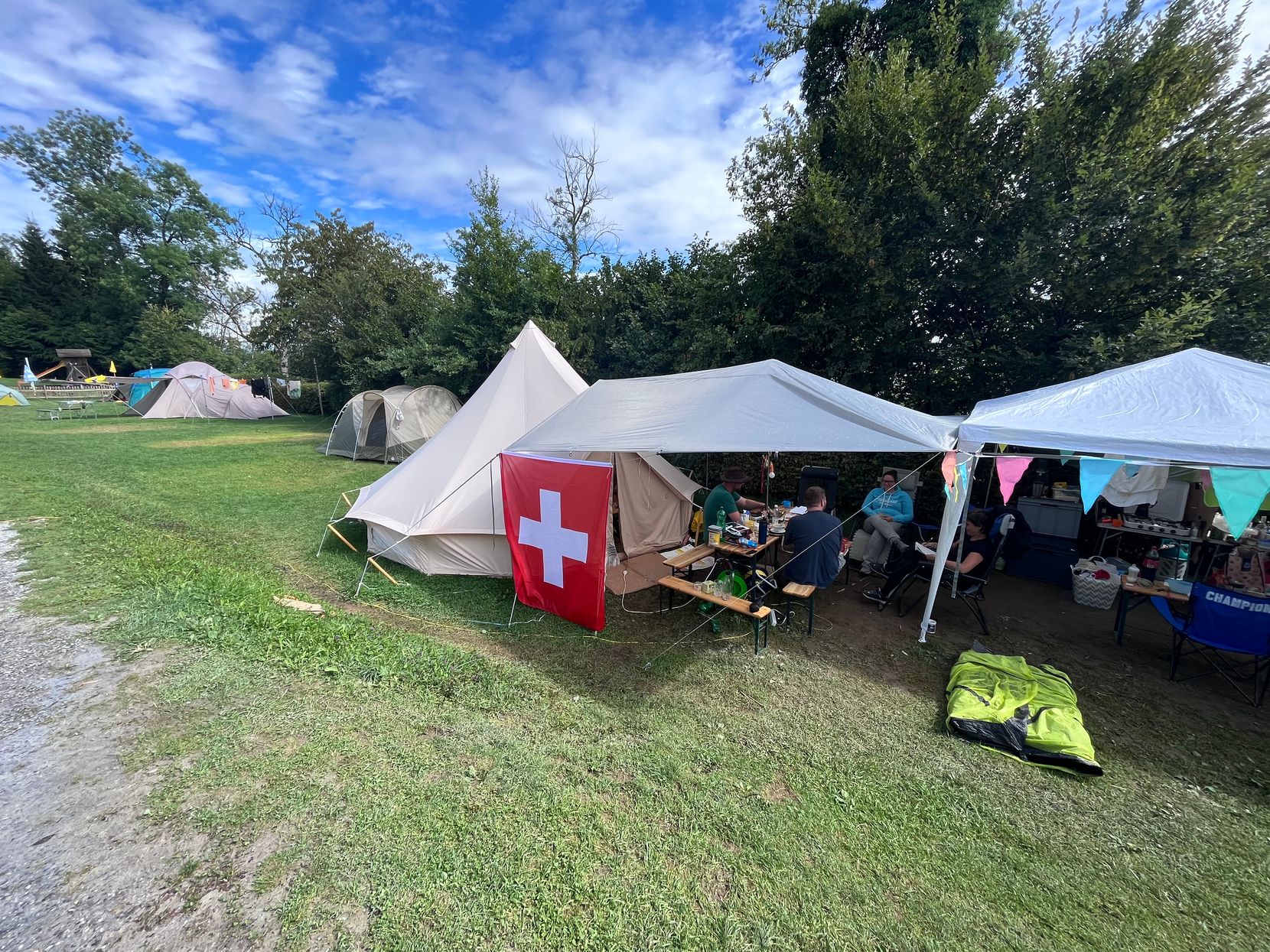 Auf dem Bild ist ein Zelt mit Schweizer Flagge auf dem Campingplatz Maurholz zu sehen.