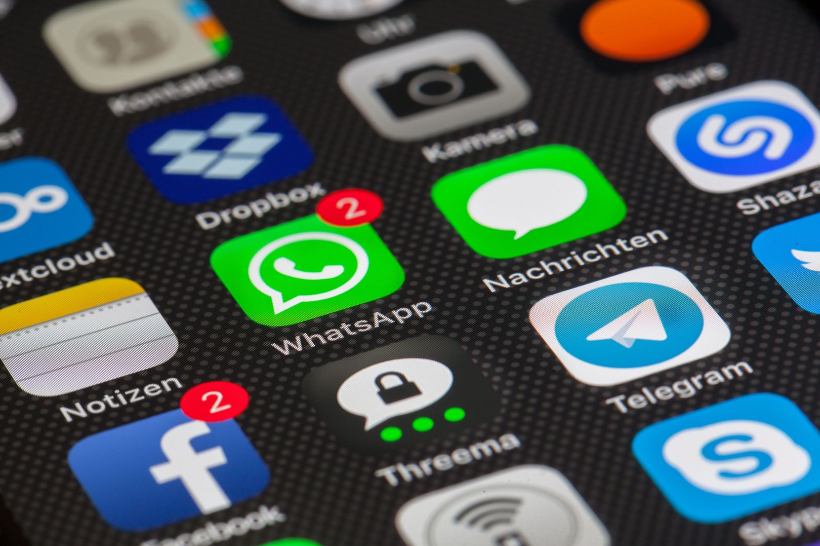 Ausschnitt eines Smartphone Bildschirms auf dem verschiedene Apps erkennbar sind, unter anderem Whatsapp, Facebook und Skype.