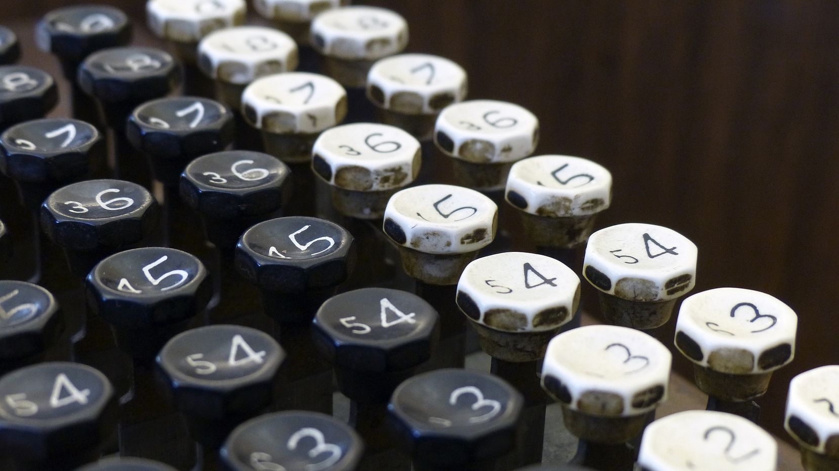 Zahlentastatur einer alten Rechenmaschine mit schwarzen und weissen Tasten.